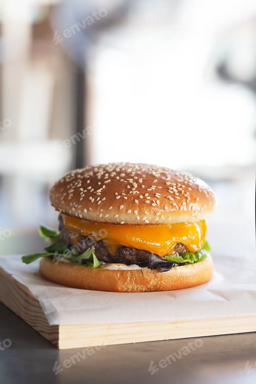 Preview: Freshly prepared burger on wooden board with copy space