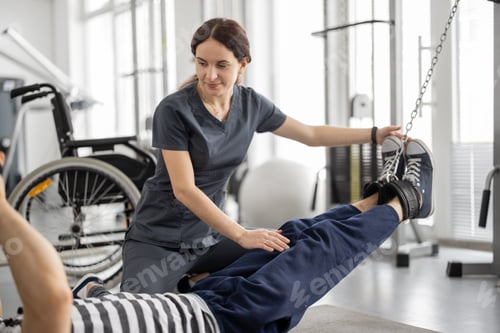 Preview: Rehabilitation specialist helps a guy to do exercise on decompression simulator for recovery