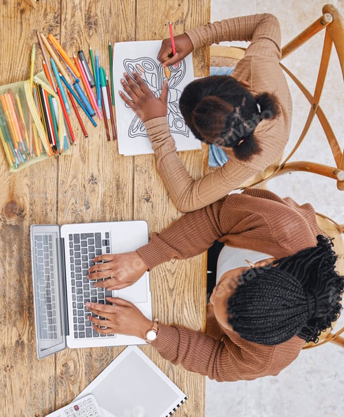 Preview: Shot of a young mother using a laptop while her daughter does homework at home