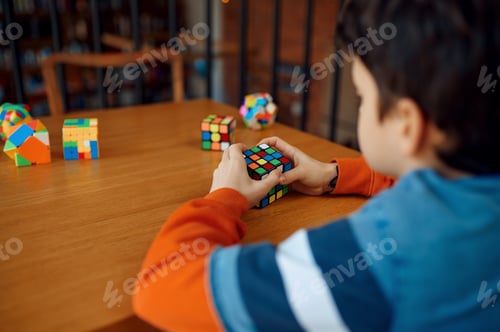 Preview: Boy holds puzzle cube, selective focus on hand