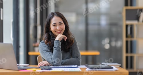 Preview: Freelancer Happy business Asian woman in knitwear taking notes at laptop sitting at desk office, f