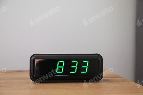 Preview: Digital alarm clock showing 8:33 o'clock on bedside table against light background, space for text