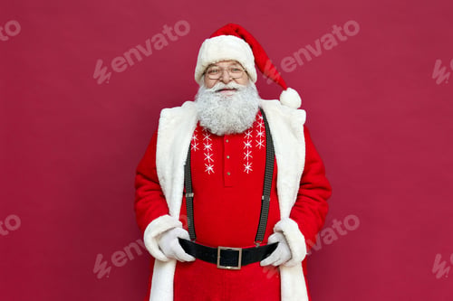 Preview: Portrait of happy old Santa Claus wearing costume isolated on red background.