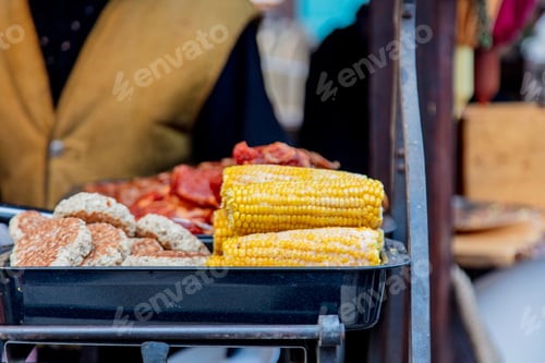Vista previa: grilled meat and corn with smoke on Christmas fair