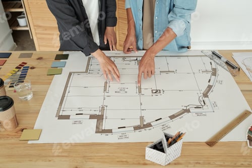 Preview: Hands of two young architects pointing at sketch on table