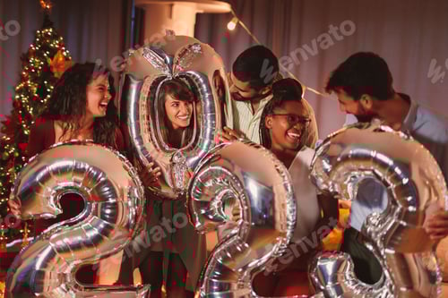 Preview: Friends holding balloons shaped as numbers 2023 representing the upcoming New Year