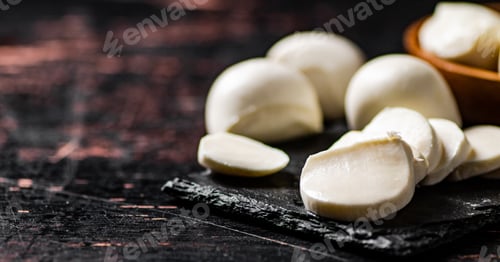 Preview: Pieces of mozzarella cheese on a stone board.