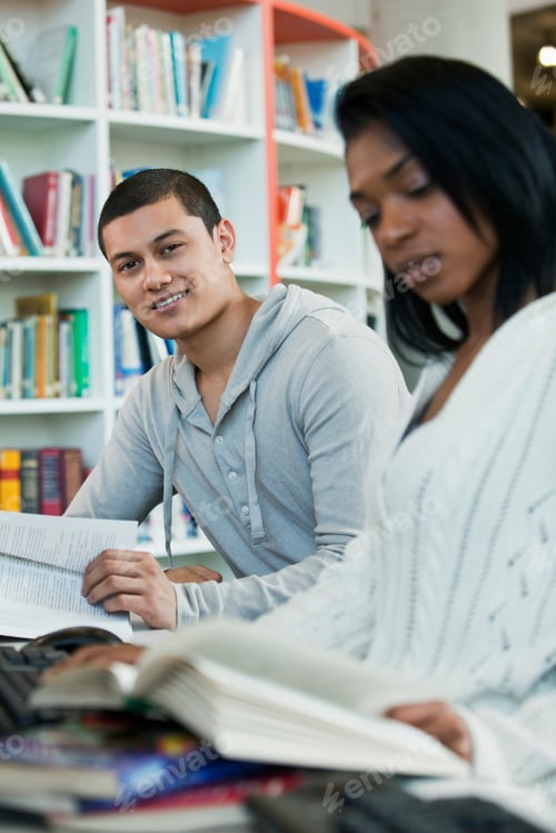 Preview: University students reading textbooks in college library, portrait