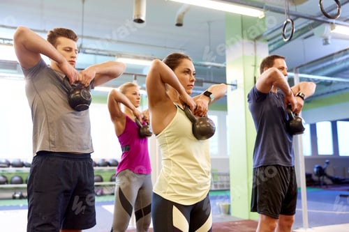 Preview: group of people with kettlebells exercising in gym