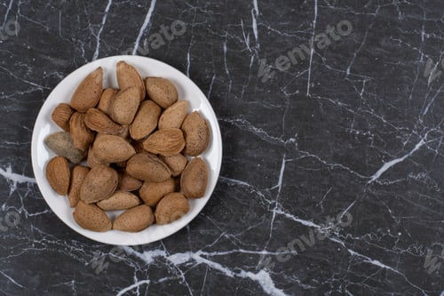 Preview: Shelled almonds in the plate , on the marble background