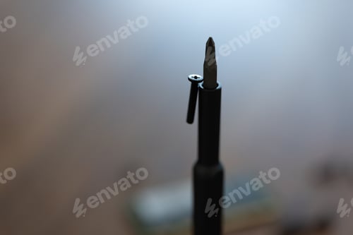 Preview: Macro shot of screw sticking on screwdriver