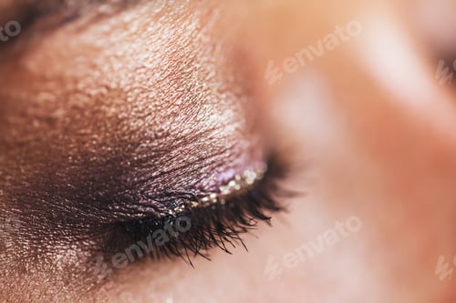Preview: Festive glowing eyeshadow make up in brown and pink colors with shiny and glitter sparkles close up.