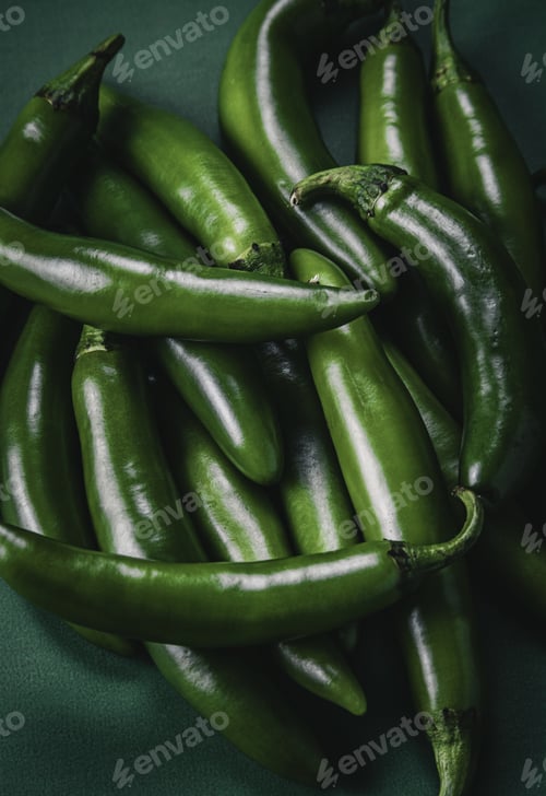 Preview: Pile of green chili peppers on a green background