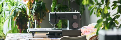 Preview: Sewing Machine Operating on Table Surrounded by Green Indoor Plants