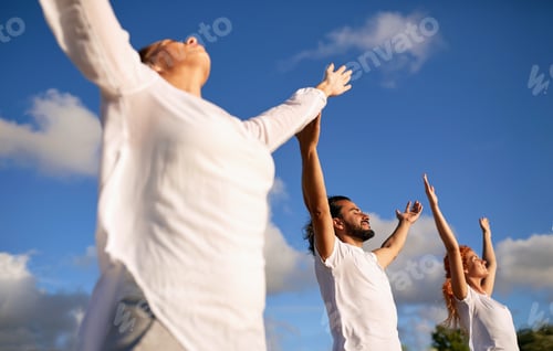 Preview: Three Adults Stretch Upwards Towards Blue Sky