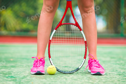 Preview: Closeup of shoes with the tennis racquet and ball outdoors on court