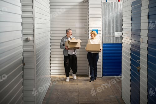 Preview: Man and lady carry box, working in storage unit