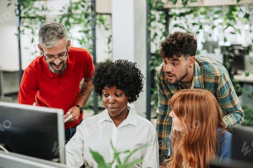 Preview: Multiracial colleagues working with laptop in office