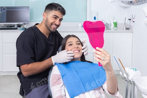 Preview: Dentist and patient admiring teeth