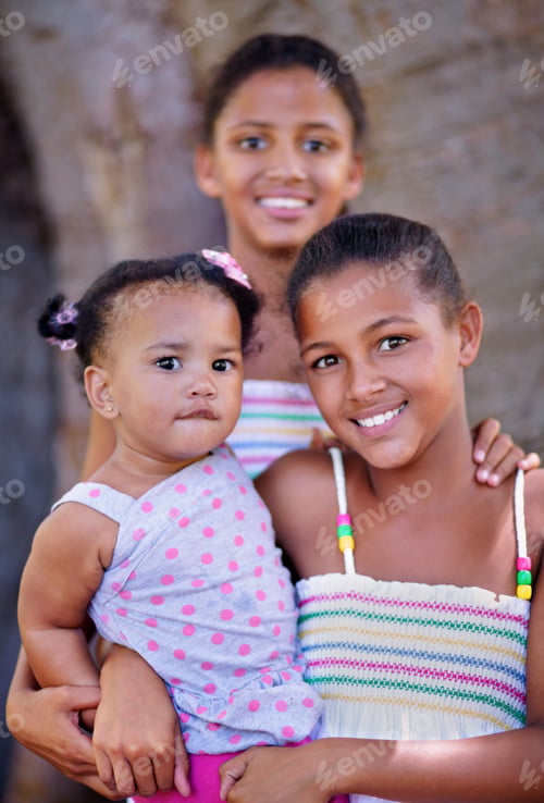 Preview: Cropped portrait of three young sisters standing together outside