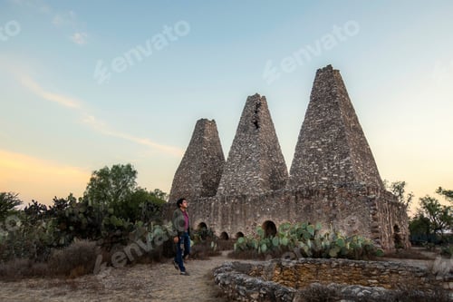 Preview: Man visiting Mine Hacienda Santa Brigida furnaces and chimneys in Mineral de Pozos Guanajuato Mexico