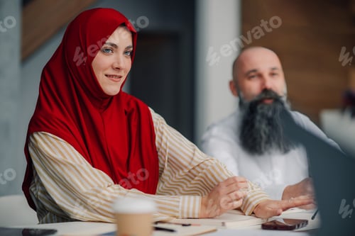 Preview: Muslim businesswoman wearing hijab attending meeting in modern office