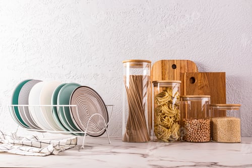 Preview: A set of eco-friendly kitchenware, plates in the dryer, glass jars with dry food on a countertop