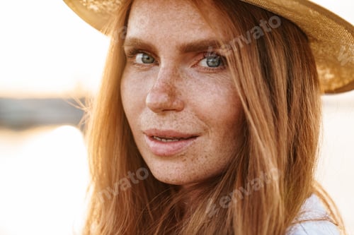 Preview: Image of pleased ginger woman in hat posing and looking at camera