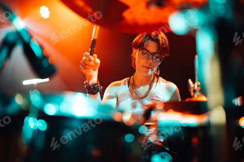 Preview: Drummer playing with drumsticks on illuminated stage