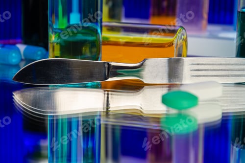 Vista previa: Metallic surgical knife and bottles of medicine.