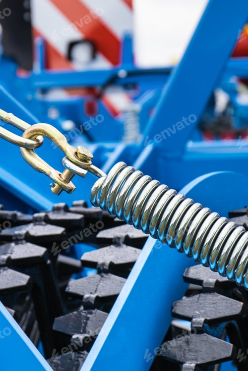 Preview: Silver spring made of steel. Part of big industrial or agricultural machine