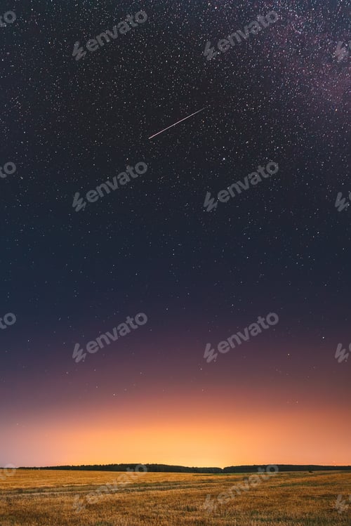 Preview: Natural Night Starry Sky Above Field Meadow. Glowing Stars, Meteorite Trail And Sunset Sunrise L...