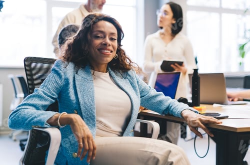 Preview: Smiling Woman Sitting in Office with Colleagues