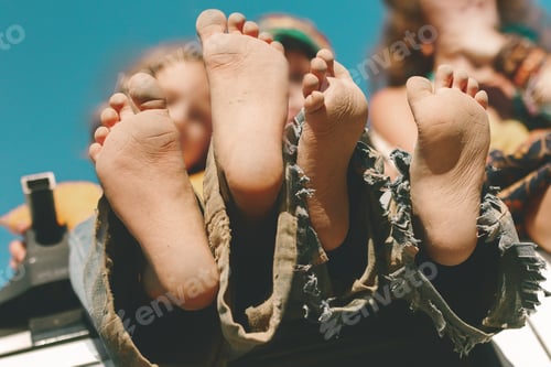 Preview: children's bare feet in torn pants bottom view, film noise, selective focus