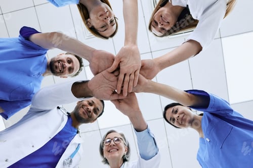 Preview: Bottom view of multiethnic medical team putting hands together in circle for success work. Patients