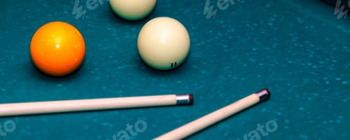 Preview: Billiard Balls and Cues Rest on a Green Felt Pool Table
