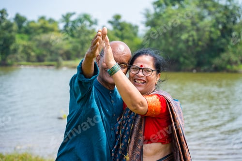 Preview: Happy Indian senior couple near river