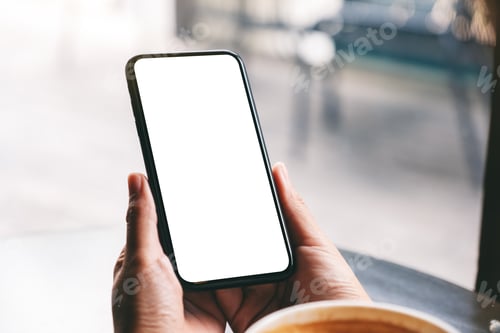 Preview: Mockup image of a woman holding black mobile phone with blank screen with coffee cup on the table