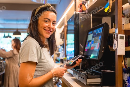 Preview: Closeup shot of a Caucasian waitress charging by card in the coffee shop