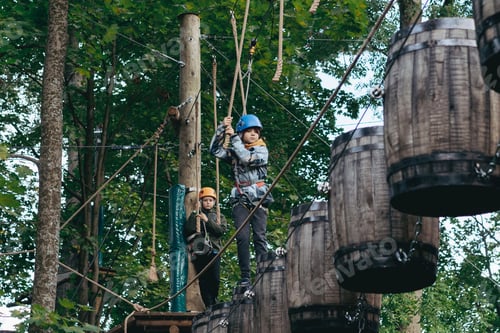 Preview: well equipped teenage boys in outdoor passing obstacle course. Active recreation in high rope park