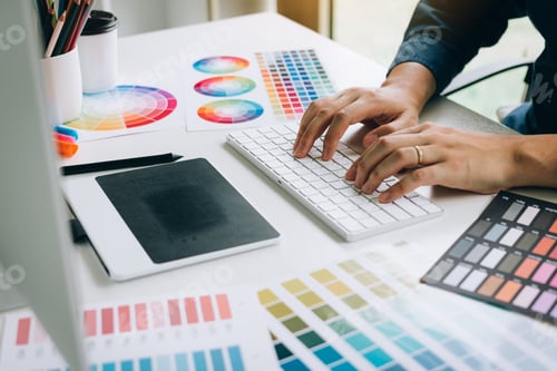 Preview: Freelance creative designers working on desk in modern home office.