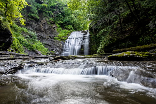 Preview: Scenic view of a waterfall in a forest surrounded by lush natur