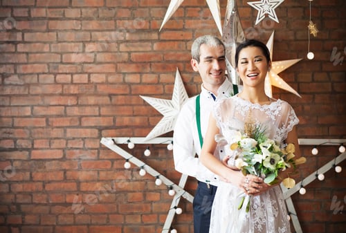 Preview: Cheerful married couple standing near the brick wall