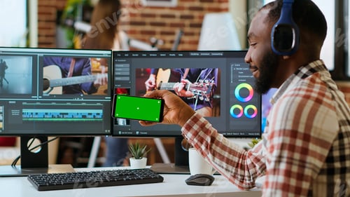 Preview: African american man edits a music video at his home office next to copy space