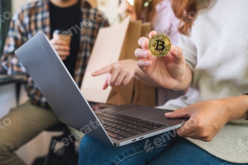Preview: Group of young people using laptop and bitcoin for shopping online together