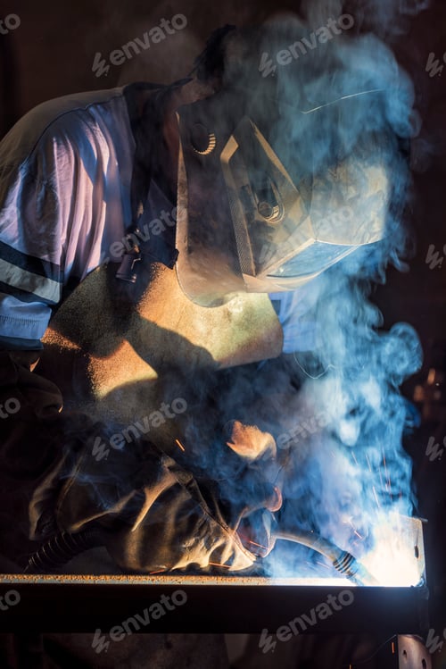 Preview: Welder works with a metal profile, iron construction production.