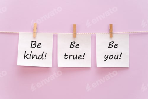 Preview: sticker with the inscription be kind, be true, be you hangs with a clothespin on a rope on a purple
