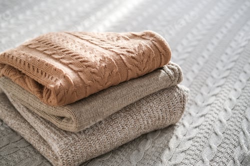 Preview: Folded Knitted Sweaters on Knitted Blanket