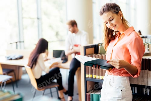 Preview: Beautiful woman reading a book in a library