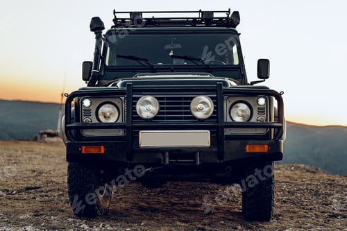 Preview: Dark green off-road car in the mountains